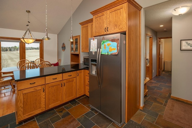 3195 115th St NW, Oronoco, MN 55960 - kitchen with appliances with stainless steel finishes, a peninsula, a textured ceiling, dark countertops, and stone tile floors