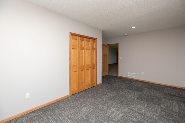 3195 115th St NW, Oronoco, MN 55960 - empty room featuring baseboards, recessed lighting, a textured ceiling, and dark carpet
