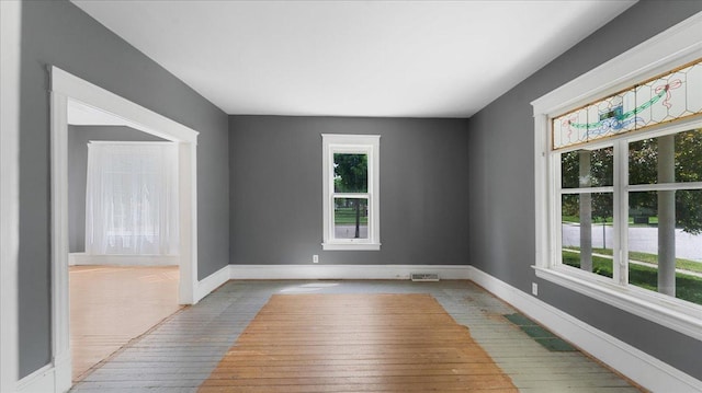 723 3rd St SW, Willmar, MN 56201 - unfurnished room featuring healthy amount of natural light, hardwood / wood-style flooring, and baseboards