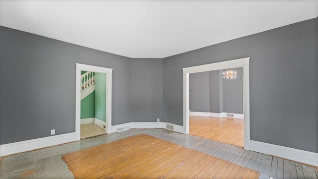 723 3rd St SW, Willmar, MN 56201 - spare room with hardwood / wood-style flooring, a chandelier, and baseboards