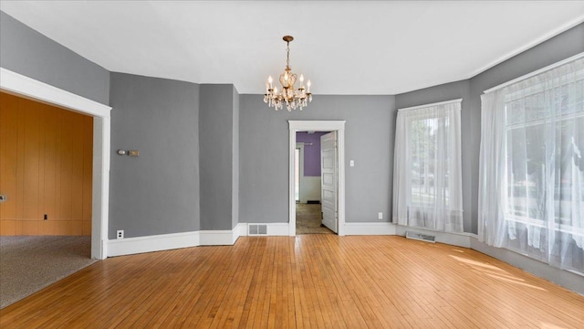 723 3rd St SW, Willmar, MN 56201 - unfurnished room with a chandelier, hardwood / wood-style flooring, and baseboards