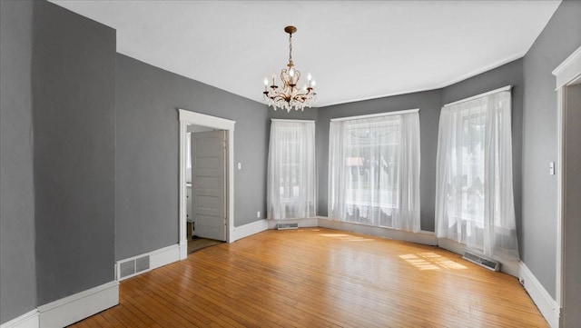 723 3rd St SW, Willmar, MN 56201 - empty room with a chandelier, hardwood / wood-style floors, and baseboards