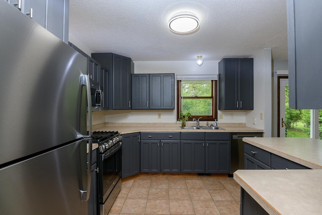 6330 Kenwood Rd, Saint Cloud, MN 56303 - kitchen with appliances with stainless steel finishes, a sink, a textured ceiling, light tile patterned flooring, and light countertops