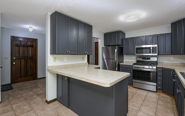 6330 Kenwood Rd, Saint Cloud, MN 56303 - kitchen featuring stainless steel appliances, a peninsula, light countertops, a textured ceiling, and light tile patterned floors