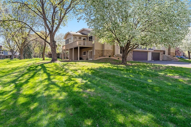 view of front of home with asphalt driveway, a front yard, and brick siding