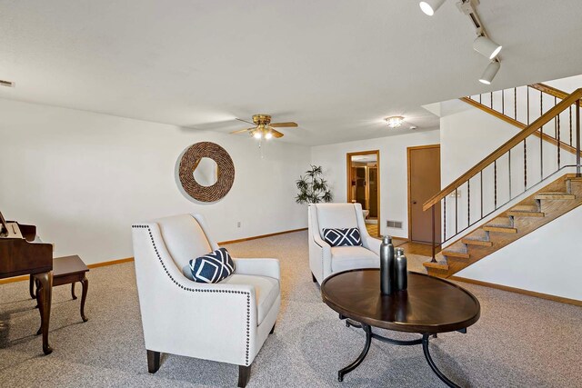 living area with ceiling fan, light carpet, and baseboards