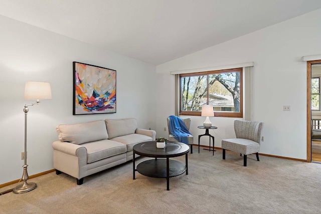 living area with light colored carpet, vaulted ceiling, and baseboards
