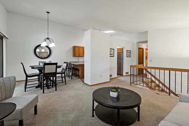 living room with light colored carpet, a chandelier, baseboards, and lofted ceiling