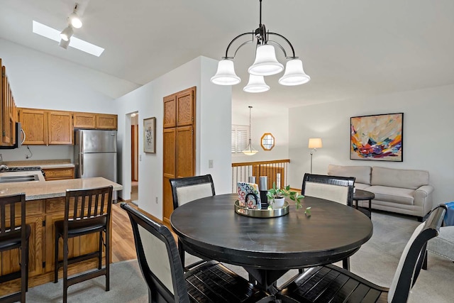 dining space featuring a skylight, a chandelier, and lofted ceiling