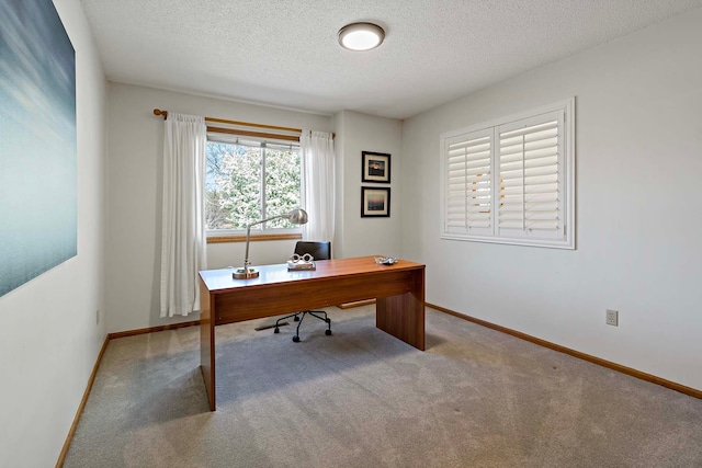 home office featuring a textured ceiling, carpet floors, and baseboards