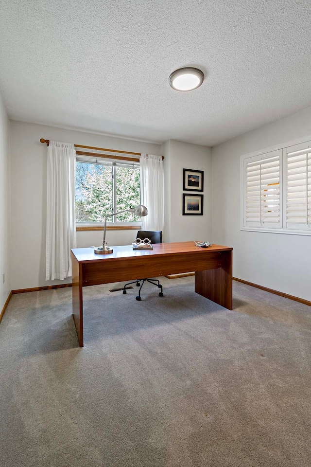 office with a textured ceiling, carpet floors, and baseboards