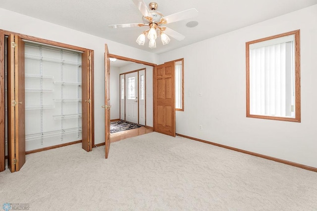 3358 70th Ave N, Moorhead, MN 56560 - unfurnished bedroom with light carpet, baseboards, multiple closets, and ceiling fan
