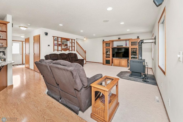 3358 70th Ave N, Moorhead, MN 56560 - living room with recessed lighting, stairway, baseboards, a wood stove, and a textured ceiling