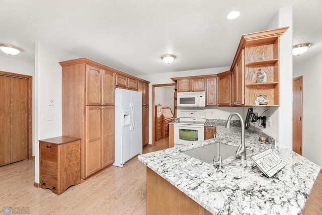3358 70th Ave N, Moorhead, MN 56560 - kitchen with white appliances, a sink, open shelves, a peninsula, and light wood finished floors