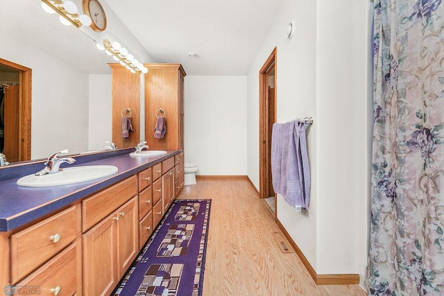 3358 70th Ave N, Moorhead, MN 56560 - bathroom with wood finished floors, double vanity, toilet, and baseboards
