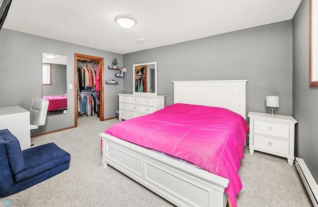 3358 70th Ave N, Moorhead, MN 56560 - bedroom featuring baseboard heating, baseboards, a closet, a walk in closet, and light carpet