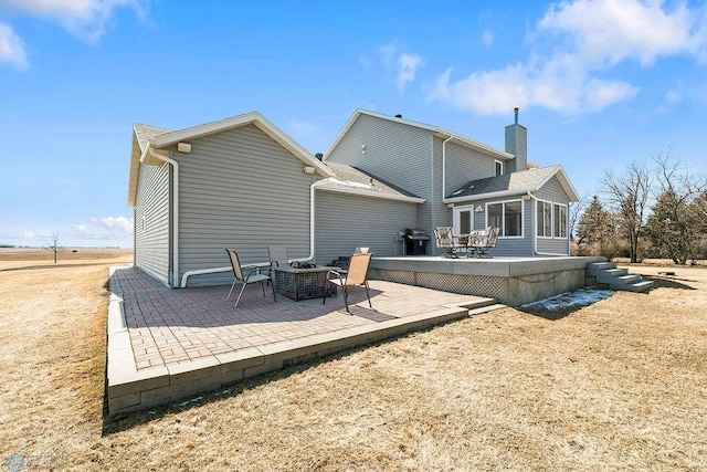 3358 70th Ave N, Moorhead, MN 56560 - back of house with a patio area, a chimney, and an outdoor fire pit
