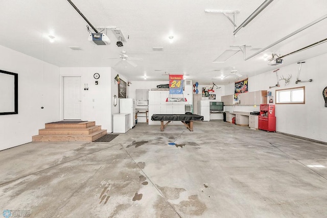 3358 70th Ave N, Moorhead, MN 56560 - garage with a garage door opener, freestanding refrigerator, and a ceiling fan