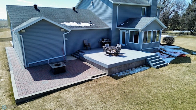 3358 70th Ave N, Moorhead, MN 56560 - rear view of house with an outdoor fire pit, a deck, a shingled roof, a yard, and a sunroom