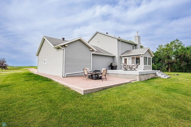3358 70th Ave N, Moorhead, MN 56560 - rear view of property featuring a patio, a yard, a chimney, and roof with shingles
