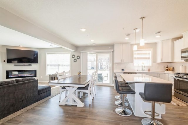 kitchen featuring white cabinets, stainless steel appliances, light countertops, and plenty of natural light