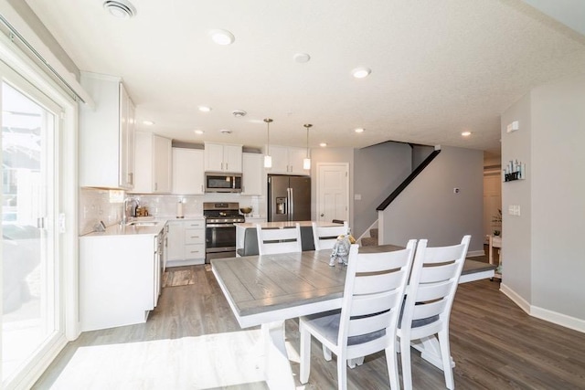 dining space featuring recessed lighting, light wood-style flooring, baseboards, and stairway