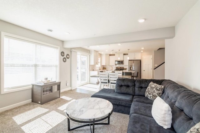 living area with light colored carpet, baseboards, stairs, and recessed lighting