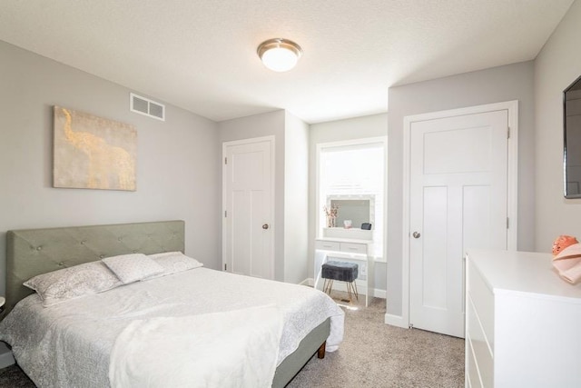 bedroom with visible vents, baseboards, and light carpet