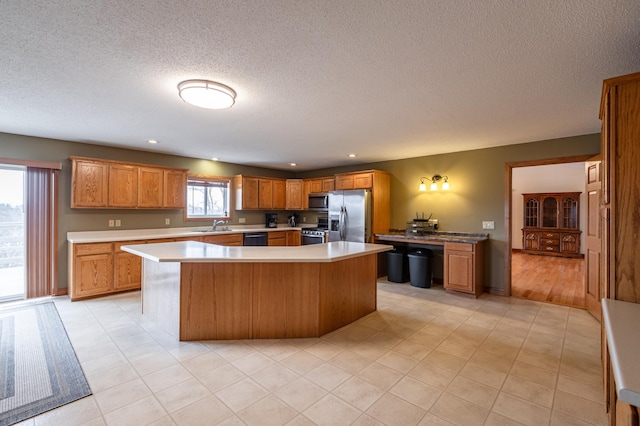 34506 Pleasant Point Dr, Homer Twp, MN 55987 - kitchen featuring stainless steel appliances, a sink, light countertops, a textured ceiling, and a center island