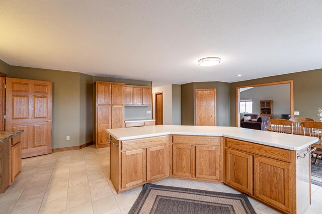 34506 Pleasant Point Dr, Homer Twp, MN 55987 - kitchen with light countertops, a center island, light tile patterned flooring, and baseboards