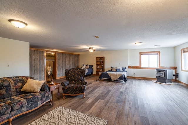 34506 Pleasant Point Dr, Homer Twp, MN 55987 - living room featuring a wood stove, wood finished floors, a textured ceiling, ceiling fan, and baseboards