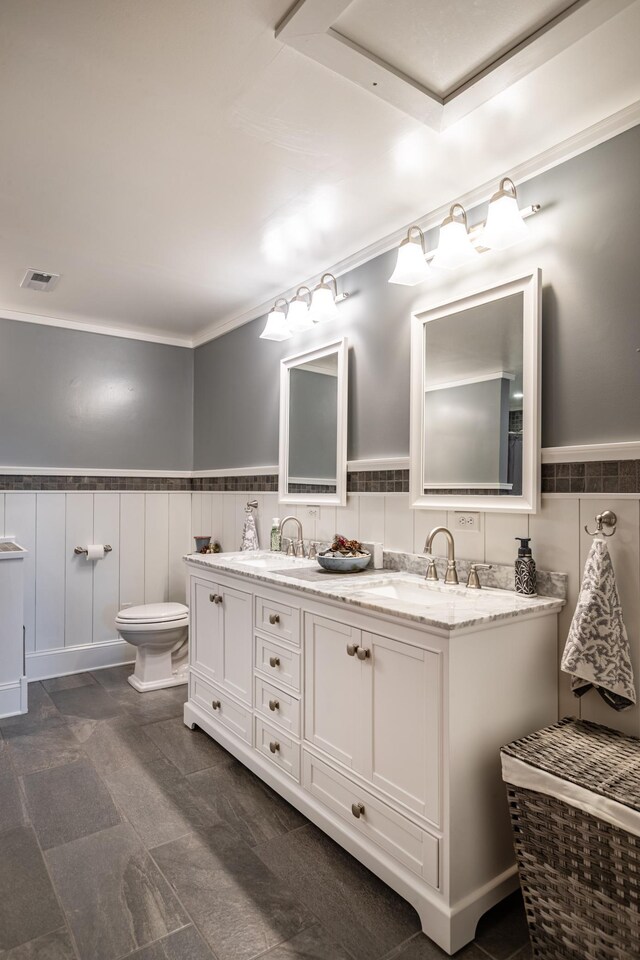 34506 Pleasant Point Dr, Homer Twp, MN 55987 - bathroom with double vanity, wainscoting, toilet, and ornamental molding