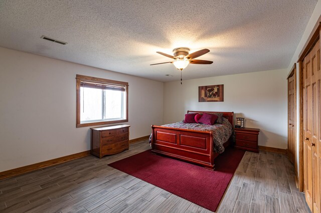 34506 Pleasant Point Dr, Homer Twp, MN 55987 - bedroom featuring wood finished floors, baseboards, a textured ceiling, and a closet