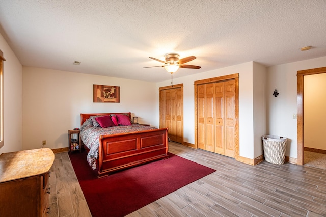 34506 Pleasant Point Dr, Homer Twp, MN 55987 - bedroom with multiple closets, baseboards, wood finished floors, and ceiling fan