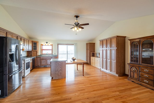 34506 Pleasant Point Dr, Homer Twp, MN 55987 - kitchen featuring fridge with ice dispenser, white gas stove, vaulted ceiling, ceiling fan, and brown cabinets