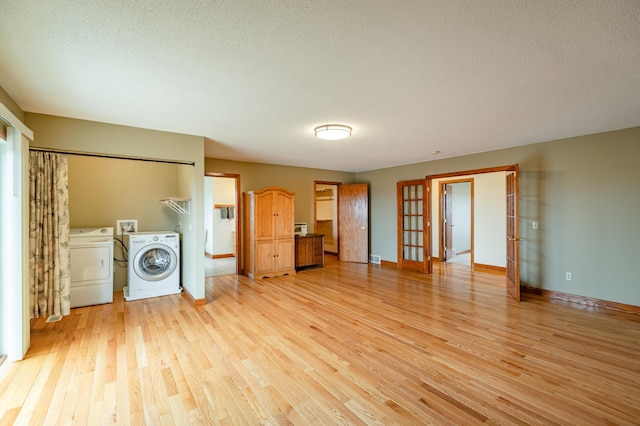 34506 Pleasant Point Dr, Homer Twp, MN 55987 - unfurnished living room with washer and dryer, light wood finished floors, french doors, baseboards, and a textured ceiling