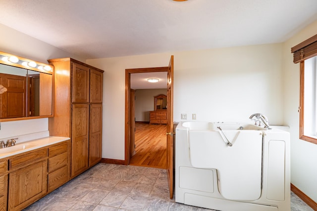 34506 Pleasant Point Dr, Homer Twp, MN 55987 - full bathroom with a garden tub, vanity, baseboards, and separate washer and dryer