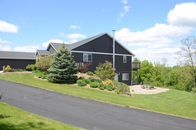 34506 Pleasant Point Dr, Homer Twp, MN 55987 - view of property exterior featuring an outdoor fire pit, a lawn, and a patio