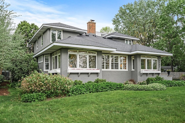 4767 Lake Ave, White Bear Lake, MN 55110 - rear view of house featuring stucco siding, a yard, a chimney, and roof with shingles
