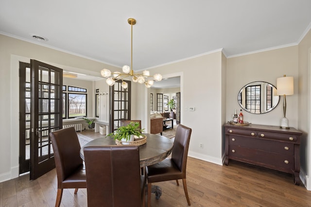 4767 Lake Ave, White Bear Lake, MN 55110 - dining area with a chandelier, wood finished floors, crown molding, and baseboards