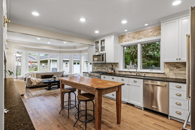 4767 Lake Ave, White Bear Lake, MN 55110 - kitchen with appliances with stainless steel finishes, a sink, ornamental molding, healthy amount of natural light, and light wood-style flooring