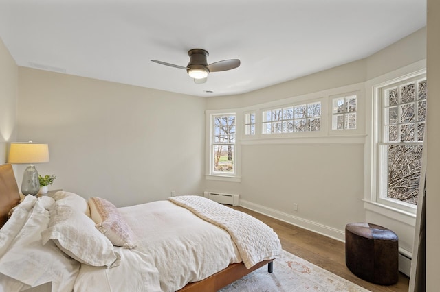 4767 Lake Ave, White Bear Lake, MN 55110 - bedroom with baseboard heating, baseboards, wood finished floors, and a ceiling fan
