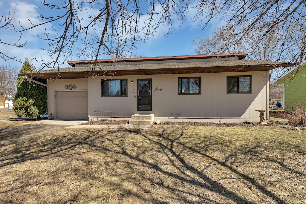ranch-style house featuring an attached garage and driveway