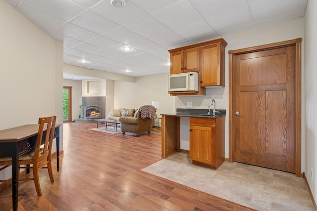 19826 Dakota Ave, Prior Lake, MN 55372 - kitchen featuring dark countertops, a sink, light wood finished floors, open floor plan, and white microwave