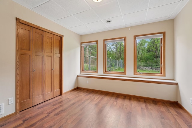 19826 Dakota Ave, Prior Lake, MN 55372 - unfurnished bedroom with multiple windows, wood finished floors, baseboards, and a paneled ceiling