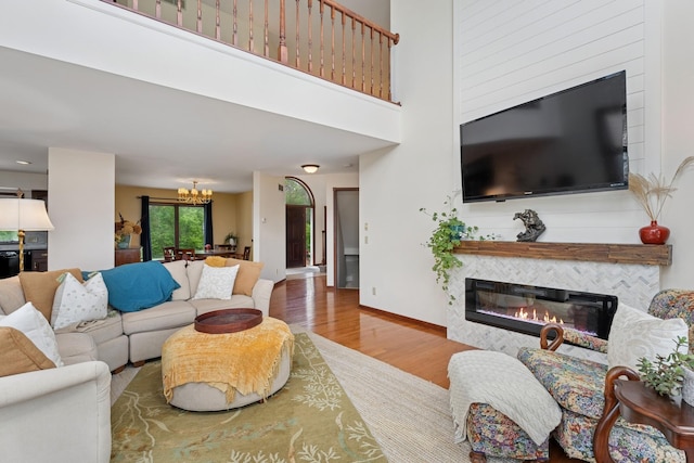 19826 Dakota Ave, Prior Lake, MN 55372 - living room featuring a fireplace, wood finished floors, a chandelier, and baseboards
