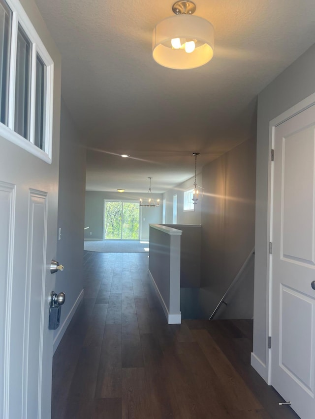1591 76th St W, Inver Grove Heights, MN 55077 - hallway featuring dark wood finished floors, an upstairs landing, baseboards, and a chandelier
