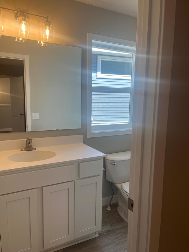 1591 76th St W, Inver Grove Heights, MN 55077 - half bath with wood finished floors, vanity, toilet, and baseboards
