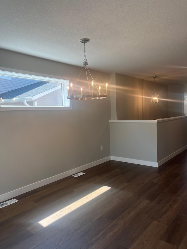 1591 76th St W, Inver Grove Heights, MN 55077 - unfurnished dining area featuring a chandelier, baseboards, dark wood-style flooring, and a textured ceiling