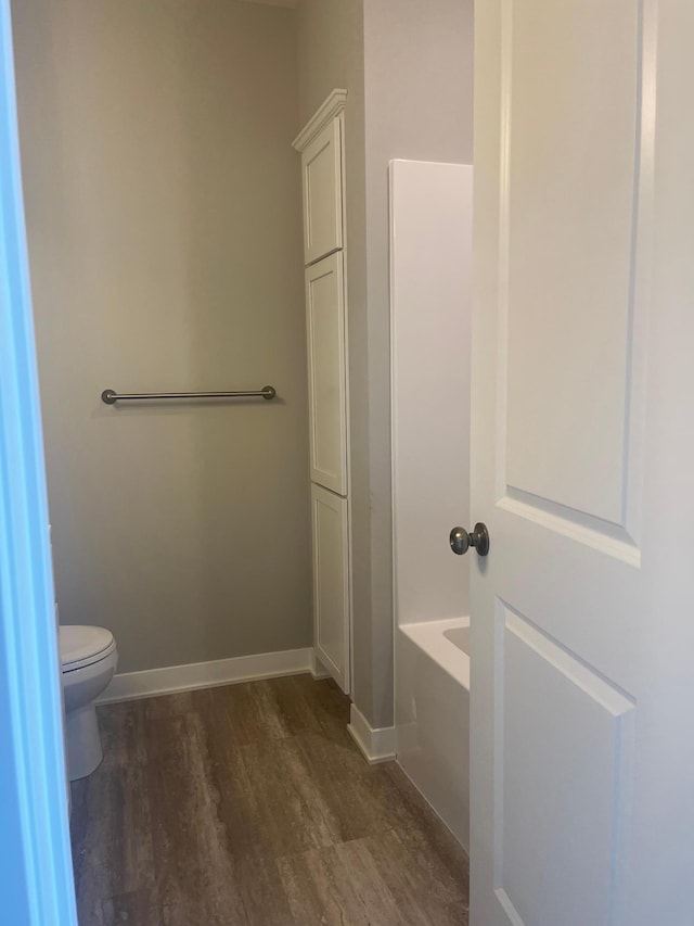 1591 76th St W, Inver Grove Heights, MN 55077 - bathroom with wood finished floors, a tub, toilet, and baseboards